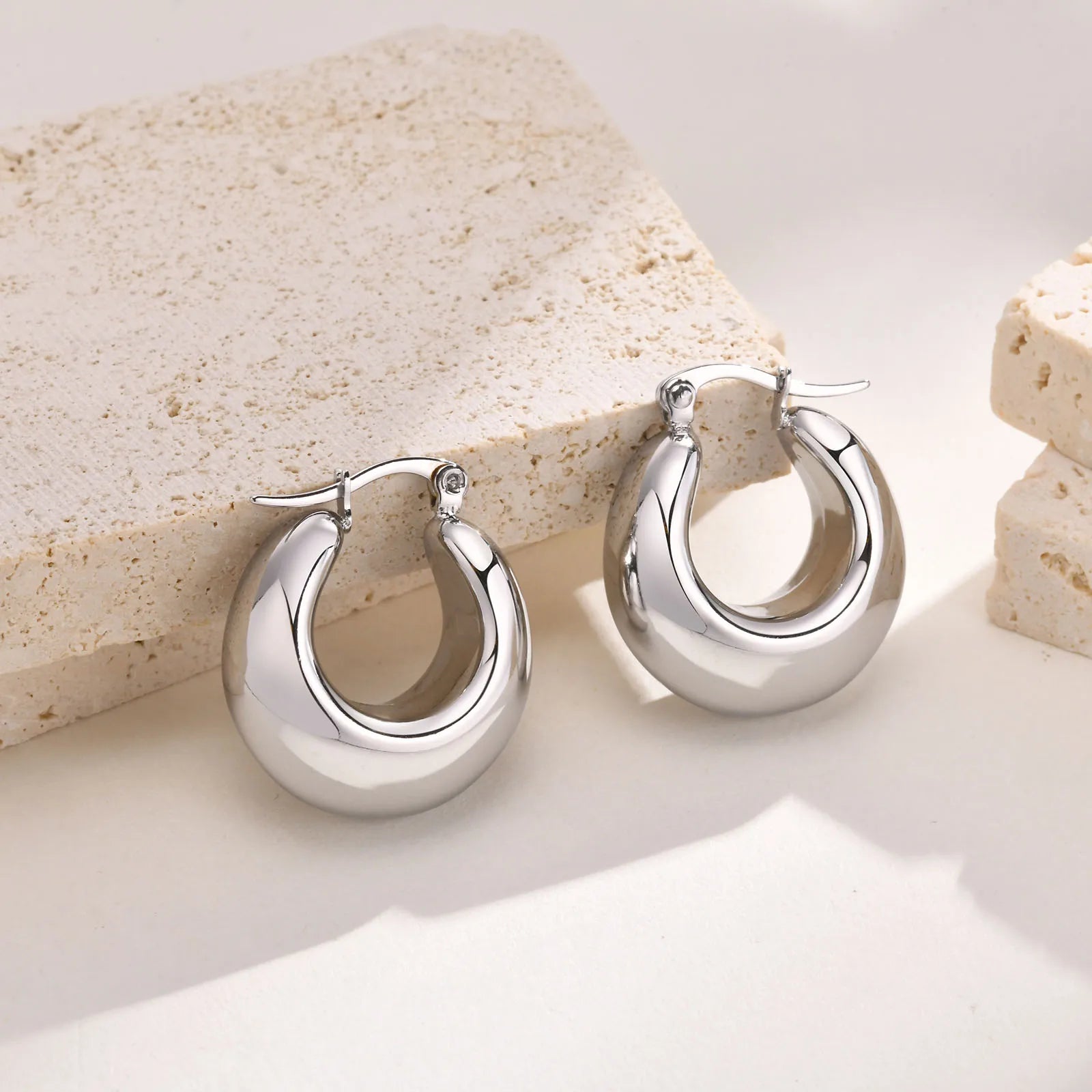 Compact gold-colored stainless steel thick hoop earrings for women.