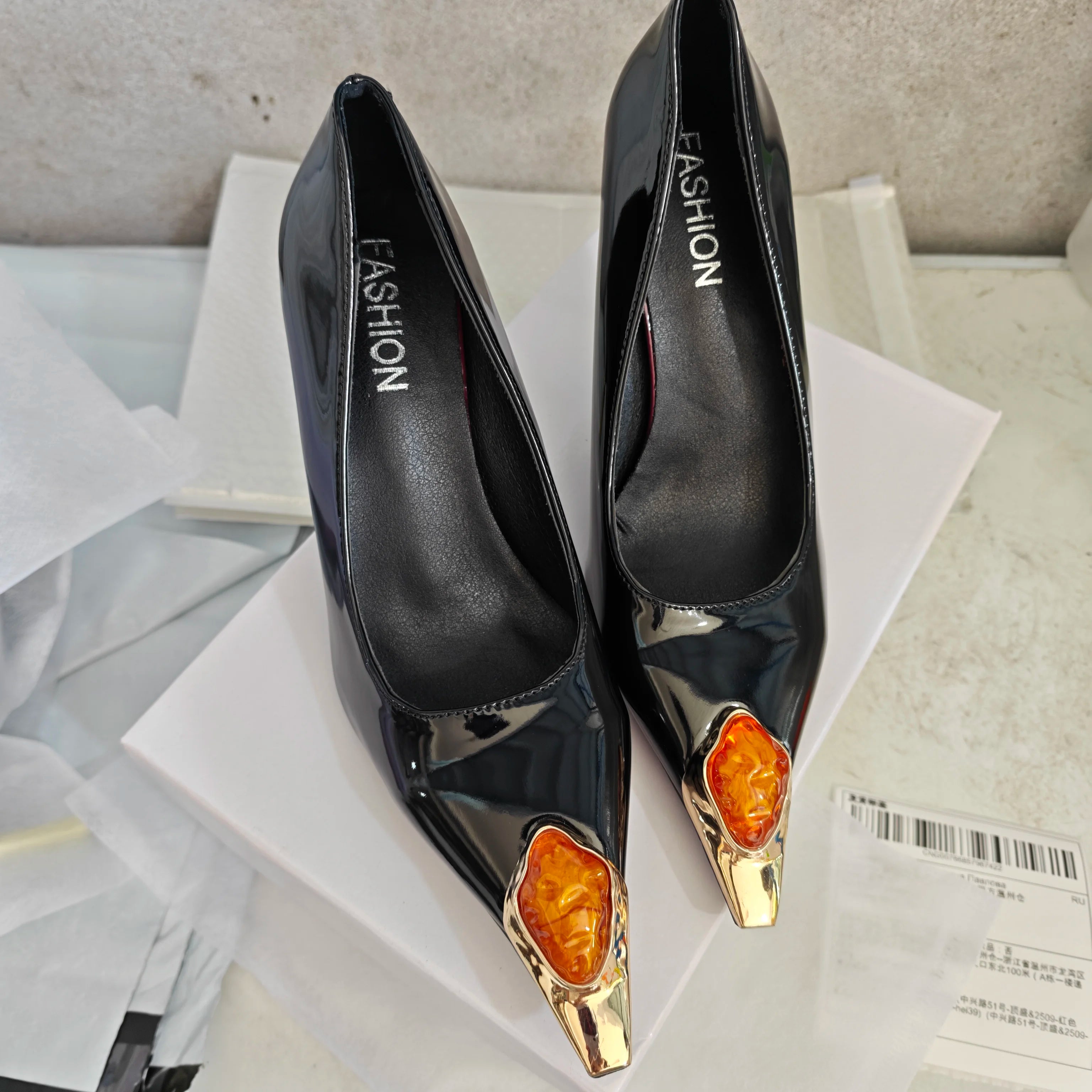 Square-toed patent leather pumps with stiletto heels and gem-studded decorations