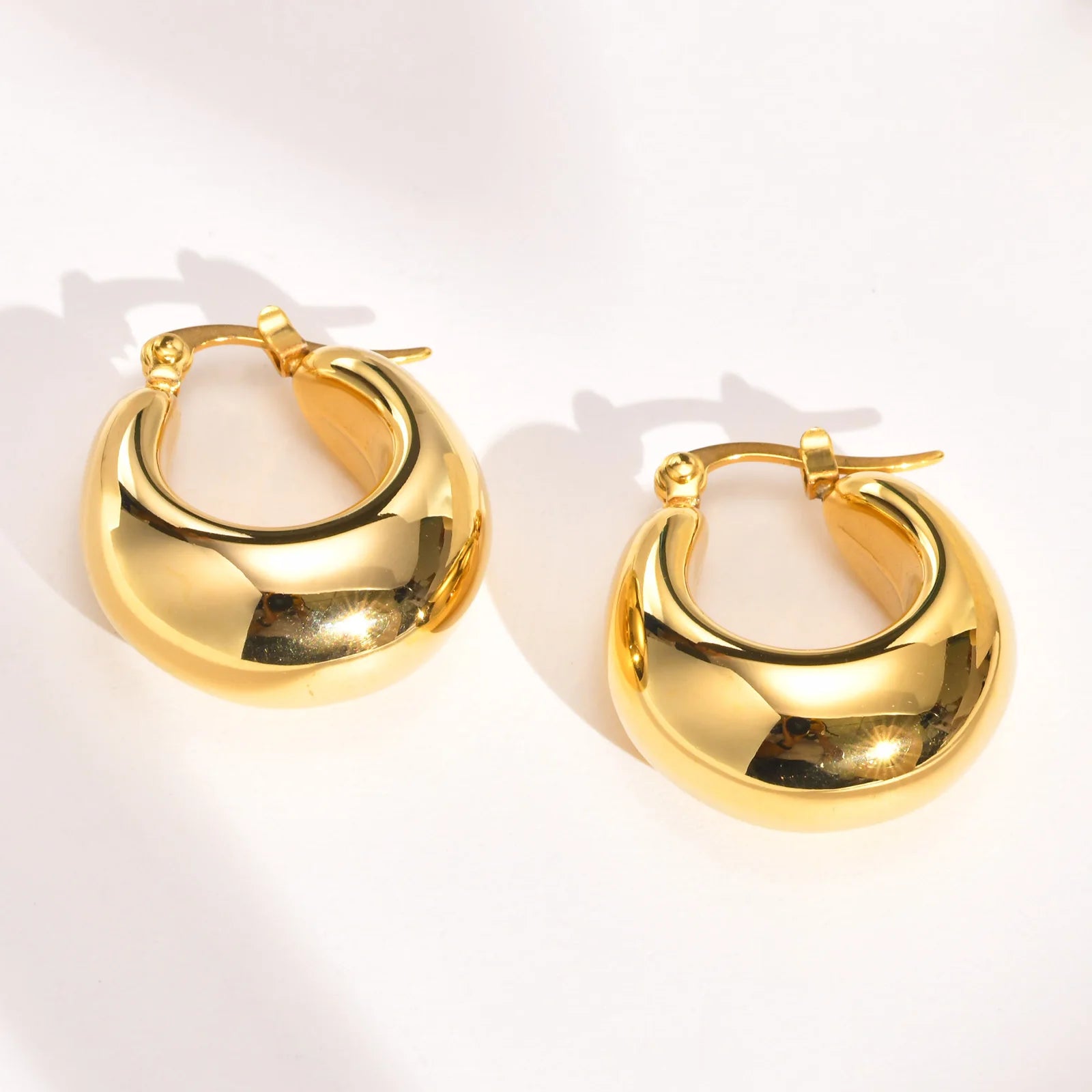 Compact gold-colored stainless steel thick hoop earrings for women.