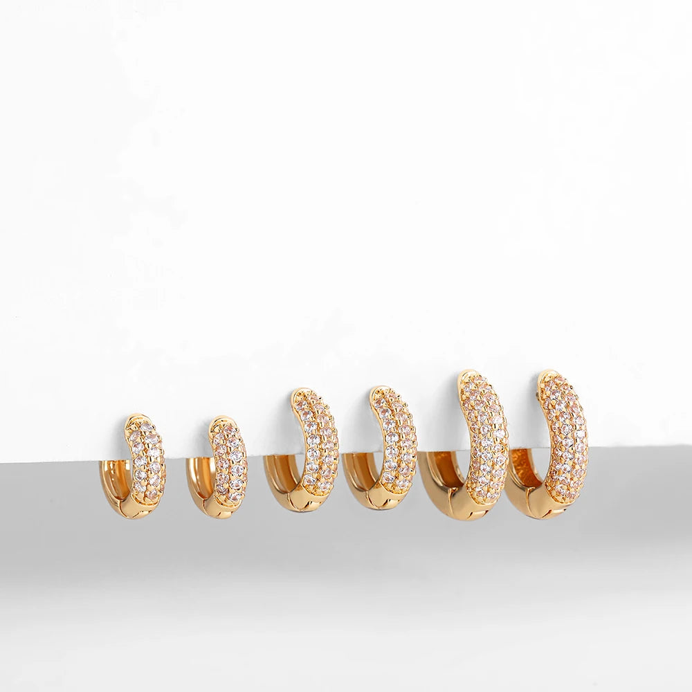 Thin gold-plated huggie hoop earrings with CZ/zircon embellishments, minimalist style.