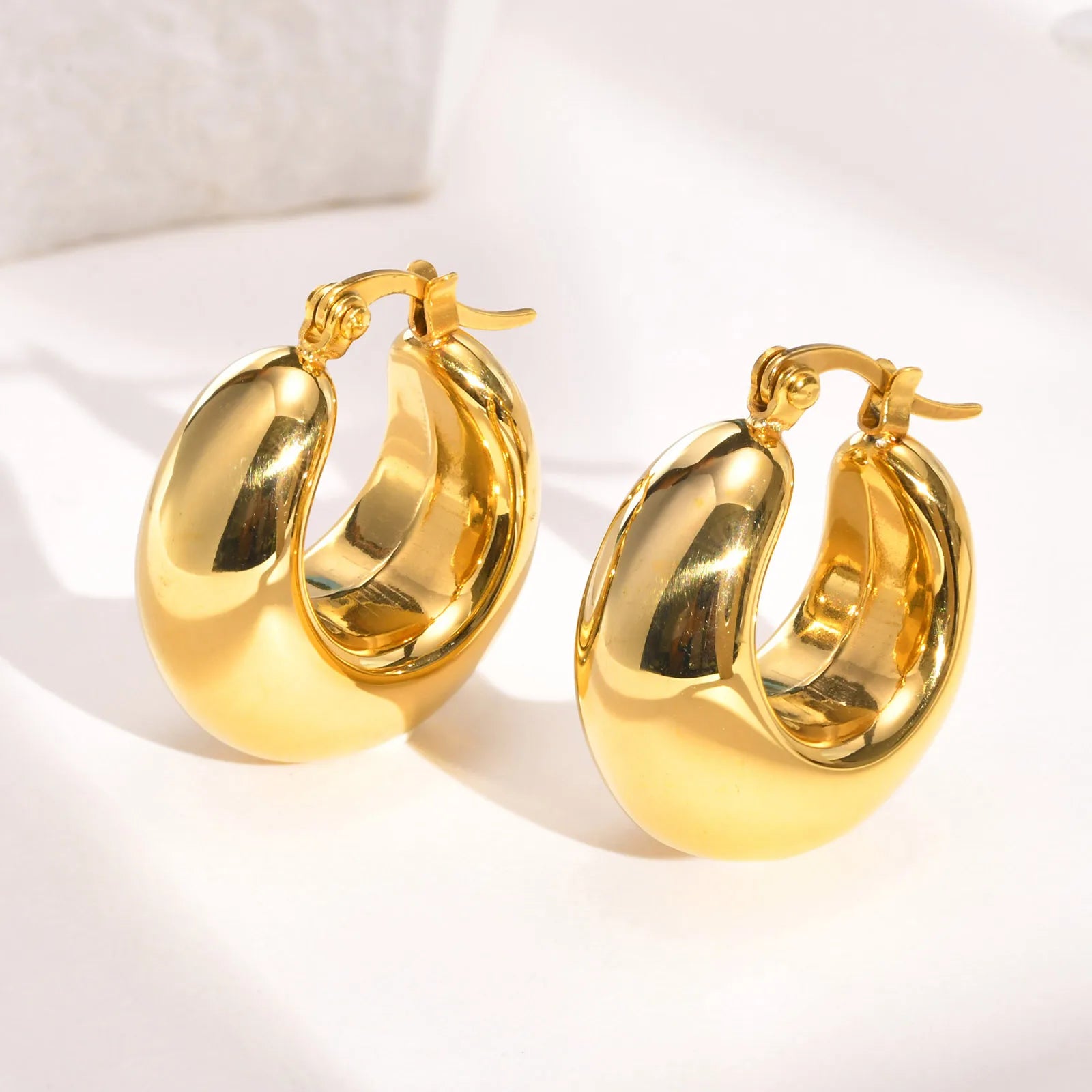 Compact gold-colored stainless steel thick hoop earrings for women.